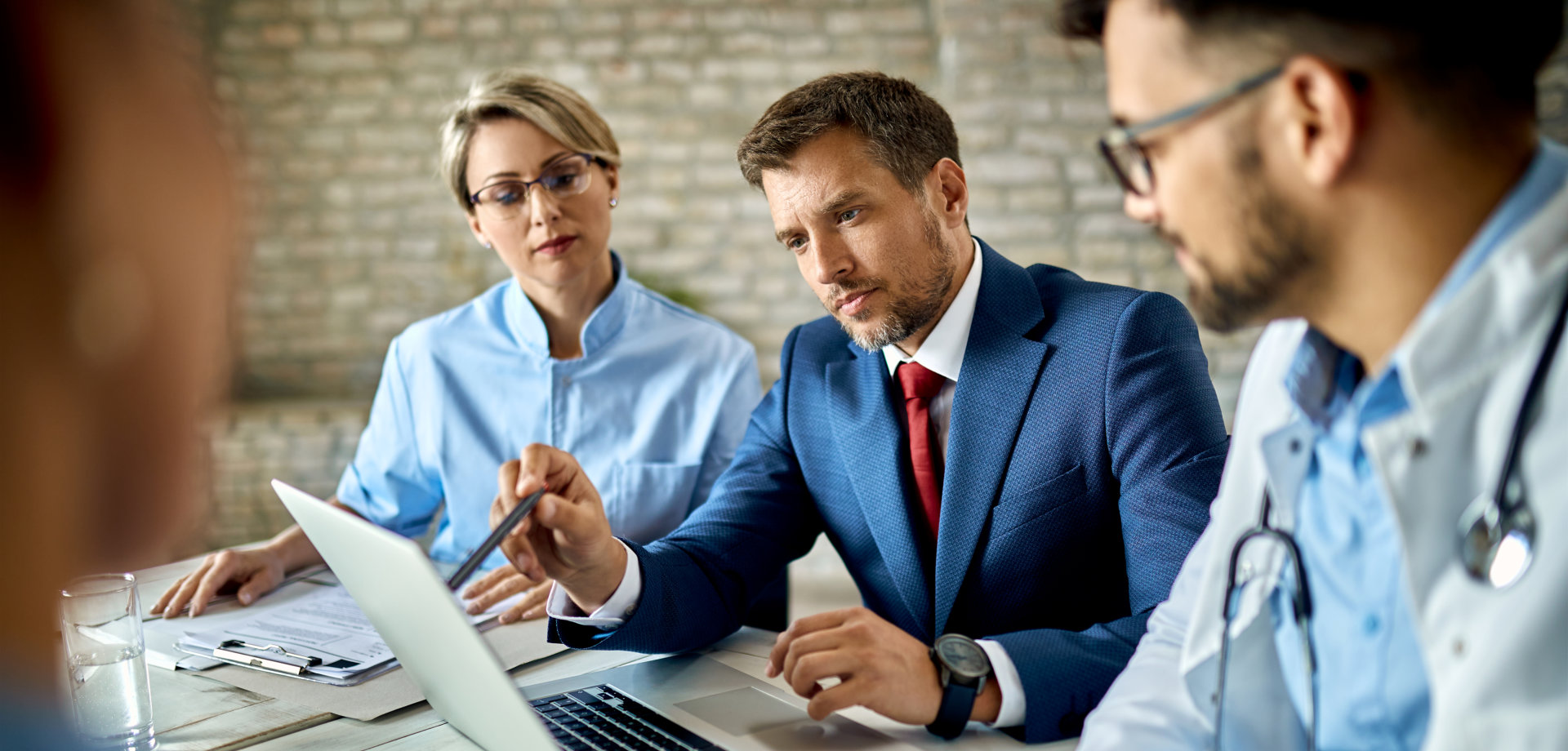 Businessman and healthcare workers using laptop on a meeting in the office.