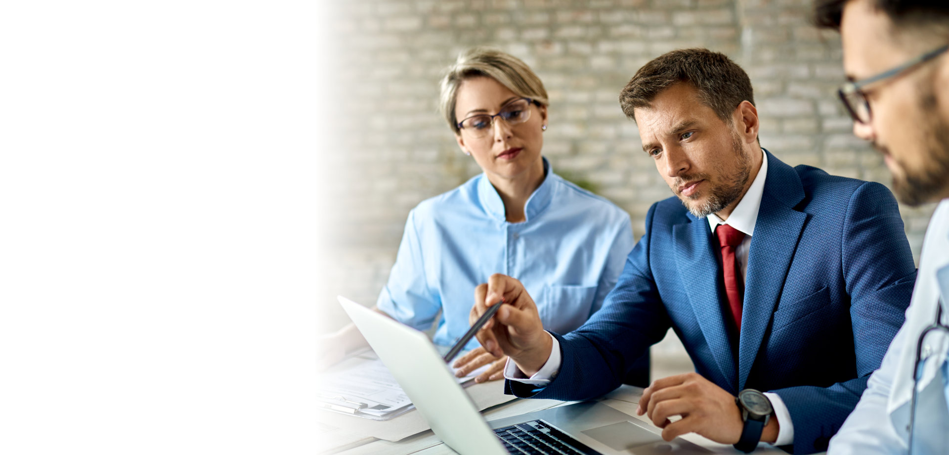Businessman and healthcare workers using laptop on a meeting in the office.