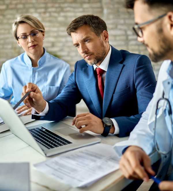 Businessman and healthcare workers using laptop on a meeting in the office.